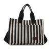 A black and white striped canvas tote bag with black handles and inner pockets.