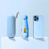 A light blue compact folding umbrella is shown next to a smartphone.