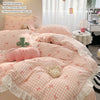 A pink and white floral patterned duvet cover set with a matching pillow and a stuffed animal on a bed.