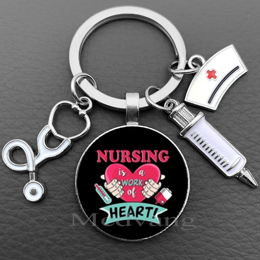 Silver necklace keychain featuring a black disc with pink heart and text saying Nursing is a work of heart