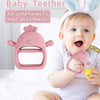 A baby is holding a pink silicone chick mitten teether designed for little hands to hold and chew on.