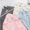 Three soft hooded baby bathrobes featuring cartoon animals in gray, cream, and pink colors.