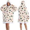 Eine Frau modelliert einen cremefarbenen, patchworkartigen Fleece-Hoodie mit festlichen Weihnachtsmustern und Kapuze.