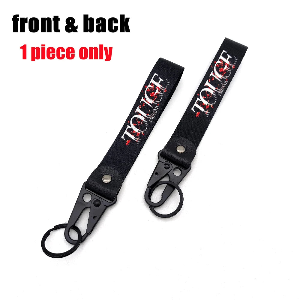 A black leather front and back 1 piece keychain with red text and eagle beak design.