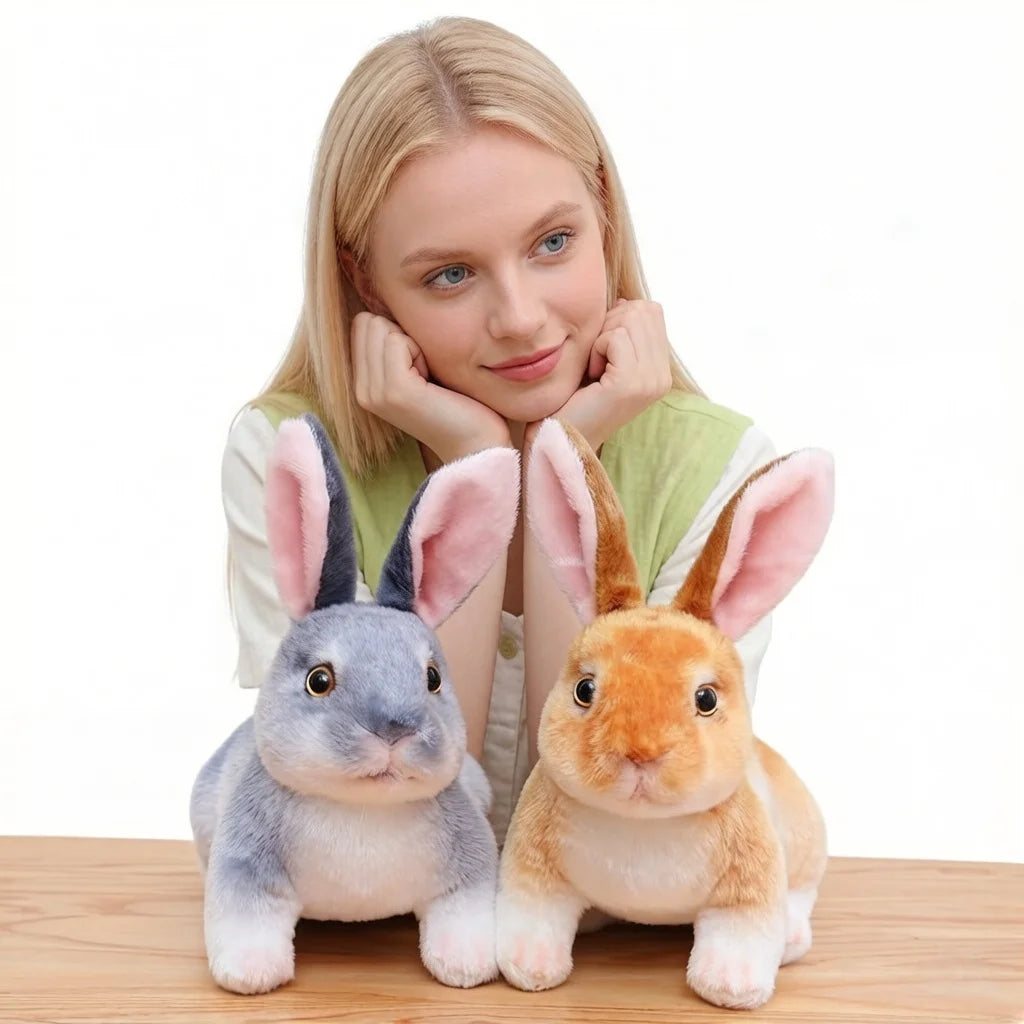 A light-colored girl is holding a fluffy gray and orange plush rabbit stuffed animal.