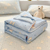 Light blue lace-trimmed breathable summer duvet folded on a white textured surface with a teddy bear.