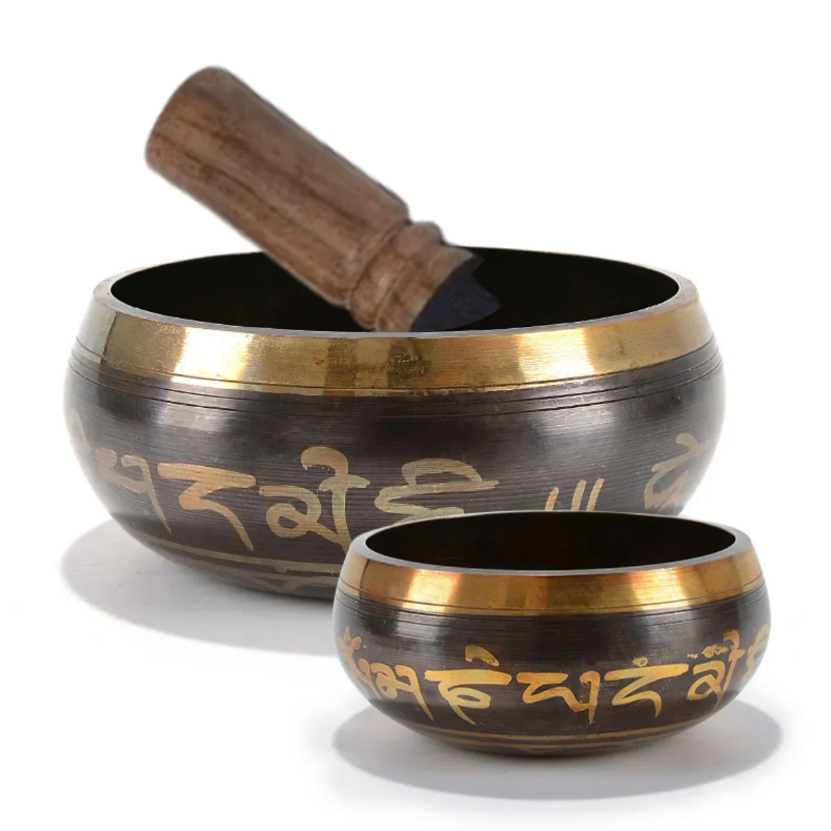 A handcrafted Tibetan singing bowl with a wooden cushion and striker, shown in profile.