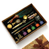 A vintage calligraphy fountain pen set with wax seal stamp kit displayed in a wooden box.