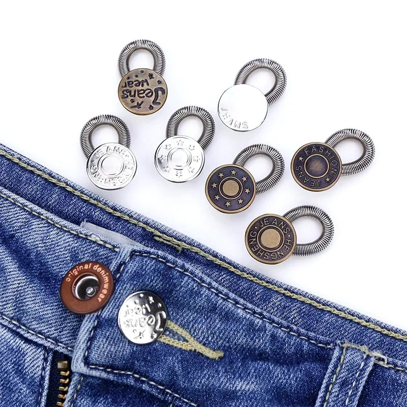 Several adjustable metal extender buttons are displayed on a piece of blue denim jeans.