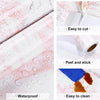 Roll of pearlescent pink marble peel and stick wallpaper showing its waterproof and easy-to-cut features.