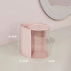 A pink clear acrylic hair accessories organizer with rotating compartments shown on a white surface.