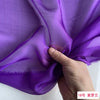 Purple silk chiffon fabric draped and held by a hand