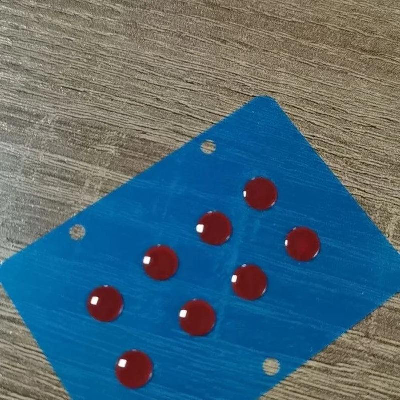 Blue glass mouse skates with several red, smooth glide feet resting on a wooden surface.