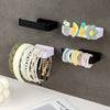 A collection of colorful beaded and natural fiber hair accessories mounted on a gray wall