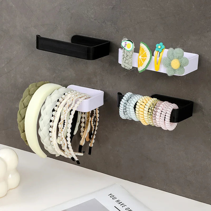 A collection of colorful beaded and natural fiber hair accessories mounted on a gray wall
