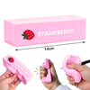 Pink strawberry shaped squishy butter fidget toy being squeezed by a hand