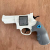 A white mini mechanical revolver water gun with a gray grip and a black chamber is shown on a wooden surface.