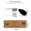 A clear glass and black silicone refillable hair fiber applicator bottle with a metal rod for precision styling.