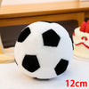 A white and black realistic football plush pillow resting on a white surface.