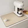 A white espresso machine is placed on a beige counter mat with a cup of coffee and some toast.