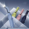 A collection of three automatic fold umbrellas in light blue, lime green, and pink, shown with LED lights activated.