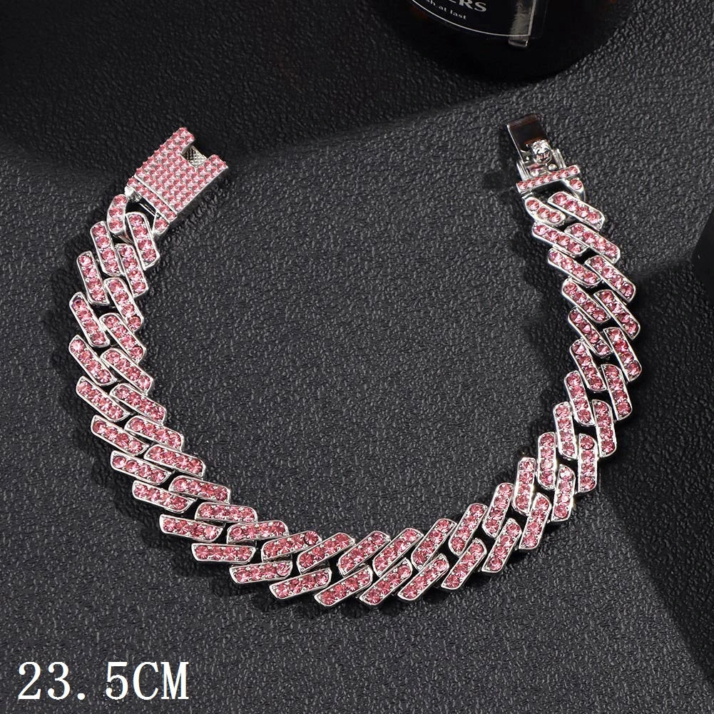 A close-up of a pink diamond iced-out Cuban link anklet displayed on a dark surface.