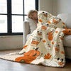 A cozy flannel throw blanket featuring an autumn design with pumpkins, maple leaves, and cute cartoon animals.