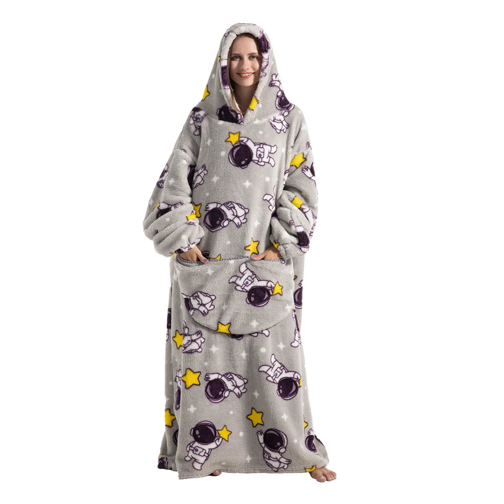 A woman wearing a gray and purple patterned oversized wearable blanket hoodie with a hood.