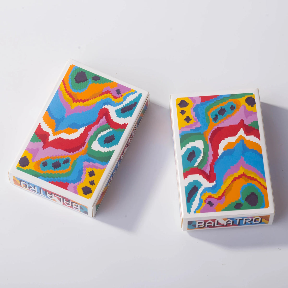A box of a classic poker card set featuring colorful, abstract geometric patterns.