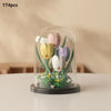 A clear glass container holds 174 small, colorful plastic flower building blocks arranged like a bouquet.