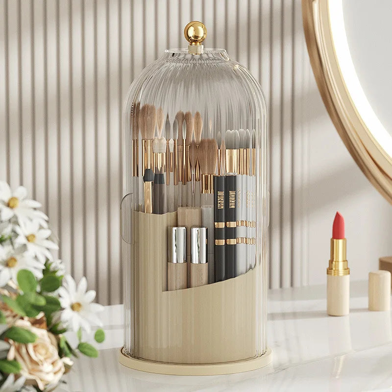 Organizador de vidrio transparente con tapa que contiene diversas brochas y herramientas de maquillaje para uso rotativo.