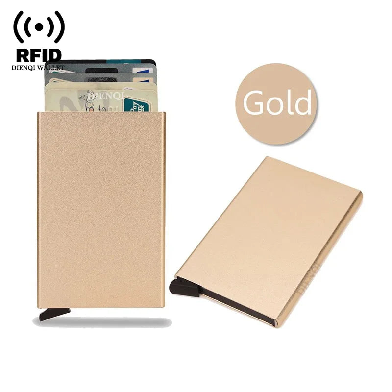 A beige slim metal RFID blocking card holder with a pop-up design next to a stack of cards and a gold circle icon.