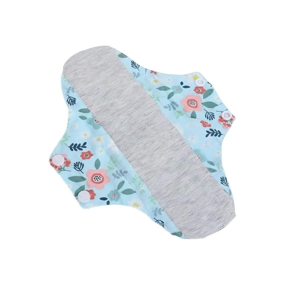 Reusable cotton menstrual pads featuring a light blue floral pattern and a gray absorbent core.
