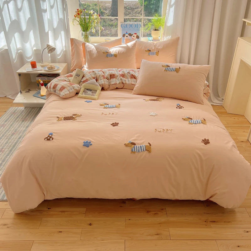 A light peach duvet cover set featuring cartoon embroidered sheep and puppy designs on a bed.