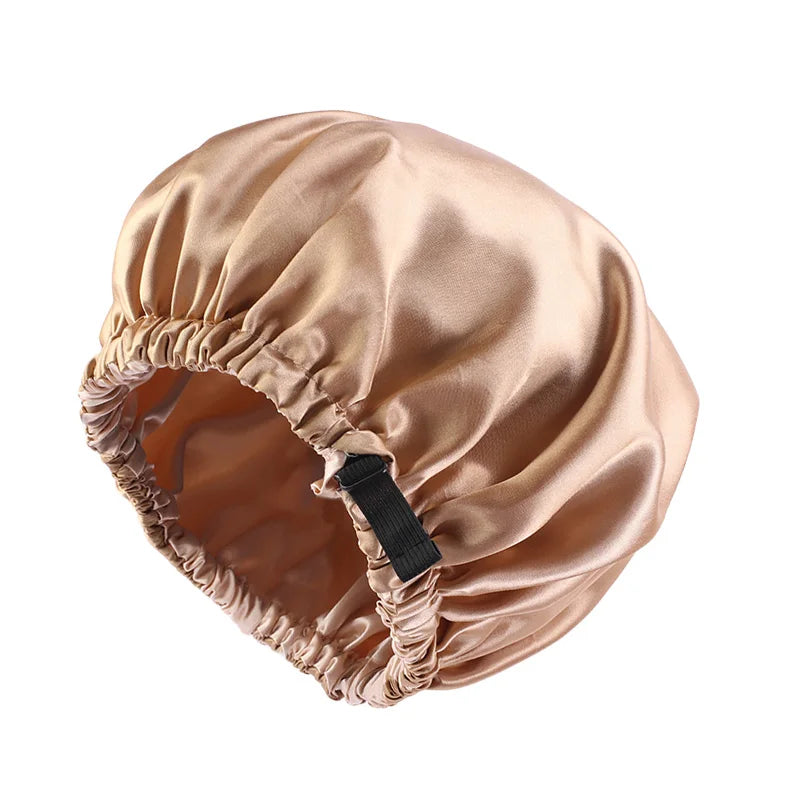 A round satin sleep bonnet in a nude or champagne color, shown from above.