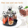 A hand holds a glass spice jar filled with reddish-brown spices, next to a set of rotating glass spice jars.