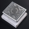 A classic stainless steel cigarette case with an embossed swirling pattern, shown open on a white box.