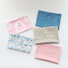 A collection of soft cotton baby pillowcases featuring various cartoon designs and patterns in pink, blue, and beige.