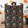 A dark gray flannel throw blanket featuring an all-over spooky Halloween print with bats, cats, and pumpkins.