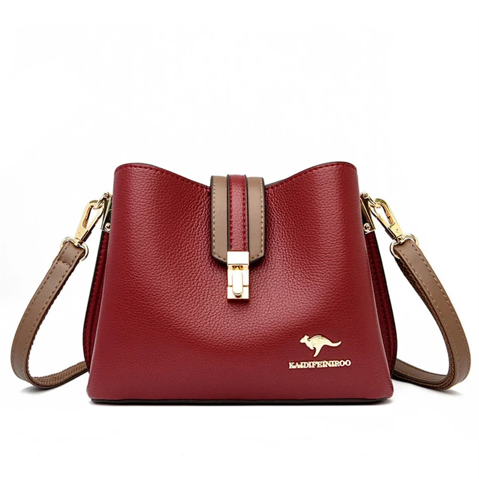 A maroon leather shoulder bag with a gold-toned clasp and strap is shown against a white background.