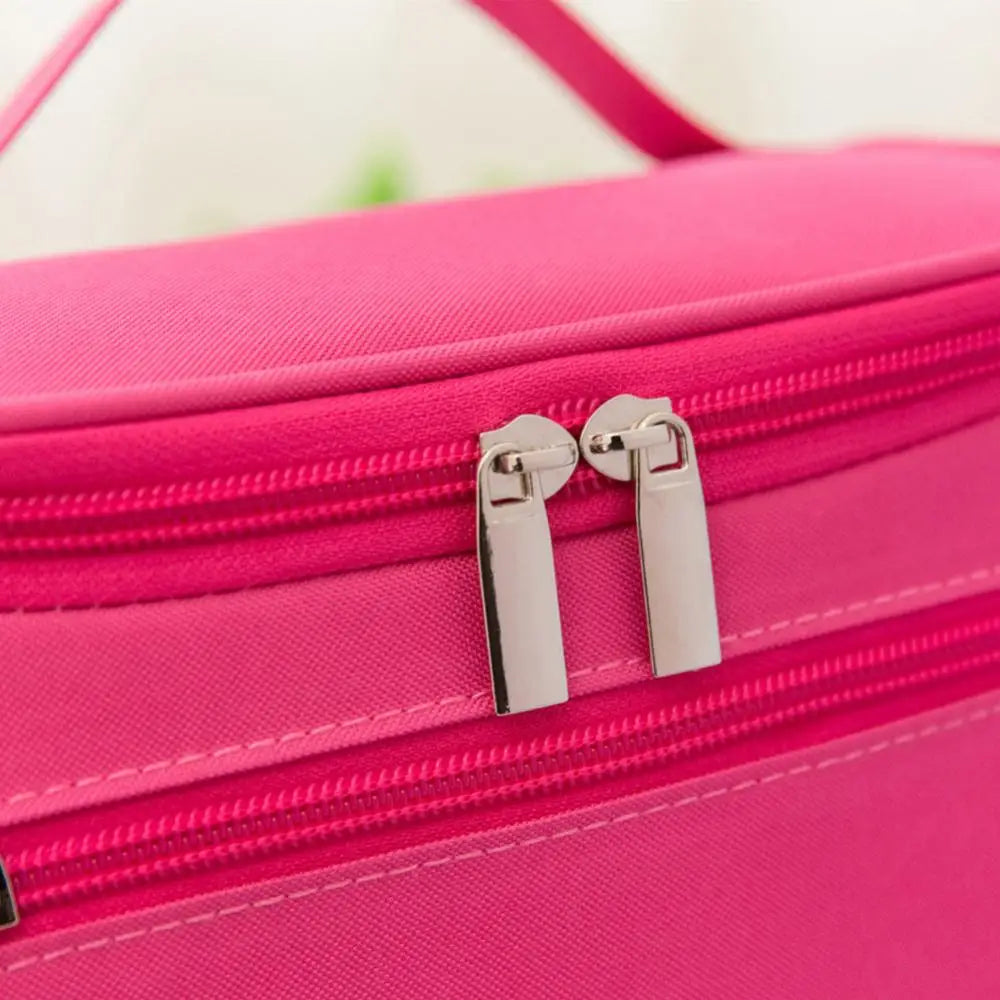 A close-up of a bright pink waterproof hanging makeup bag with silver zippers.