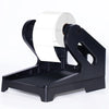 A black thermal label holder device with a white roll of labels inserted.