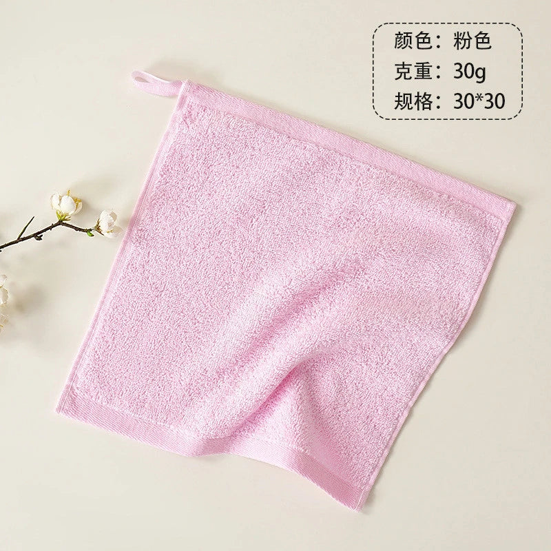 A pink, fluffy organic cotton face towel is shown flat on a light background.