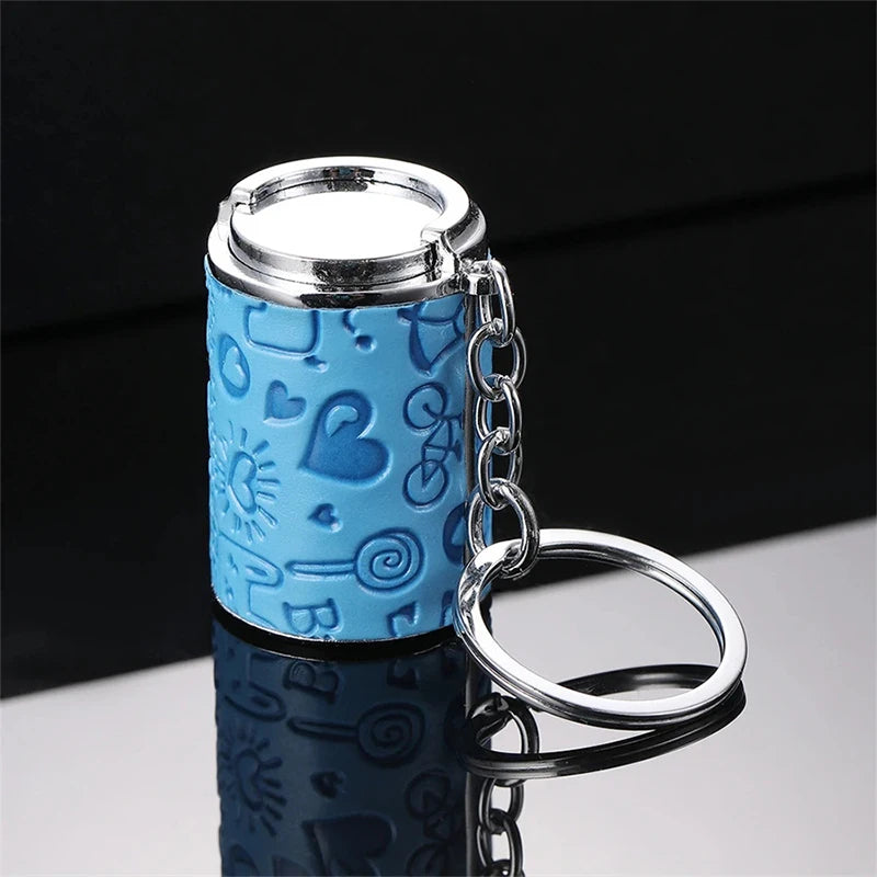 A light blue metal coin tube keychain with a silver cap and chain, reflecting on a surface.