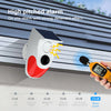 A white solar motion sensor alarm device is mounted on a building, demonstrating its sound levels against a scale.