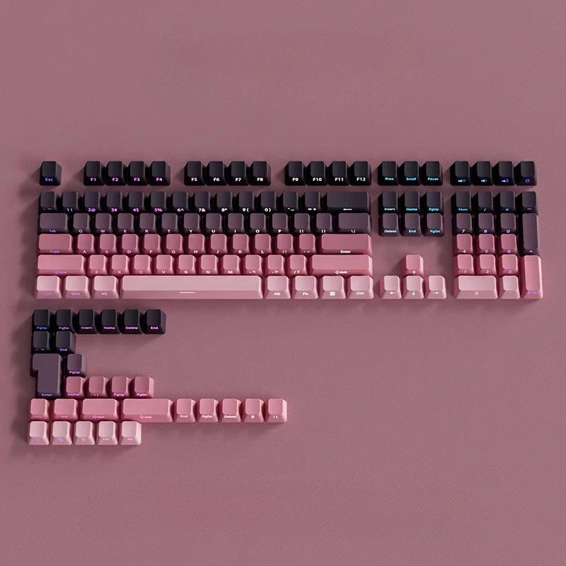 Nahaufnahme von rosa-schwarzen Farbverlauf-PBT-Tastenkappen auf einer flachen Oberfläche.