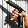 A hand grips an ergonomic black and yellow handle of a sensitive grip trigger tool with a silver shaft.