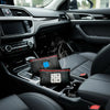 A black reusable car dehumidifier bag with a visual humidity indicator resting in the center console of a car interior.