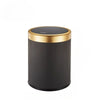 A cylindrical trash can with a black textured body and a gold rim and lid.