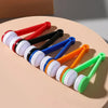 A collection of colorful portable double-sided glasses cleaning brushes with microfiber pads arranged on a light background.
